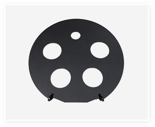 Round black metal plate featuring multiple circular cutouts.