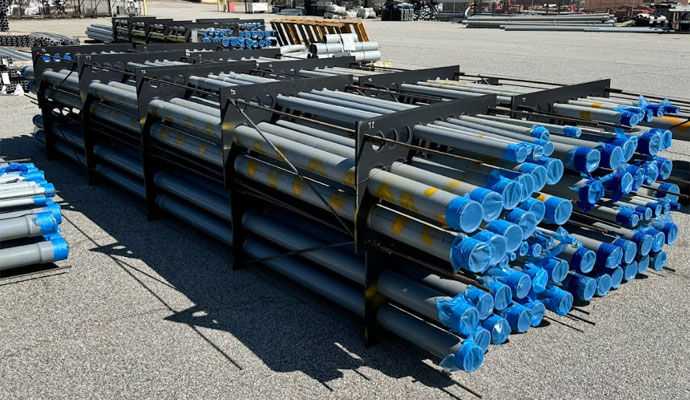 Stacked conduit banks with black spacers secured for transport on a jobsite